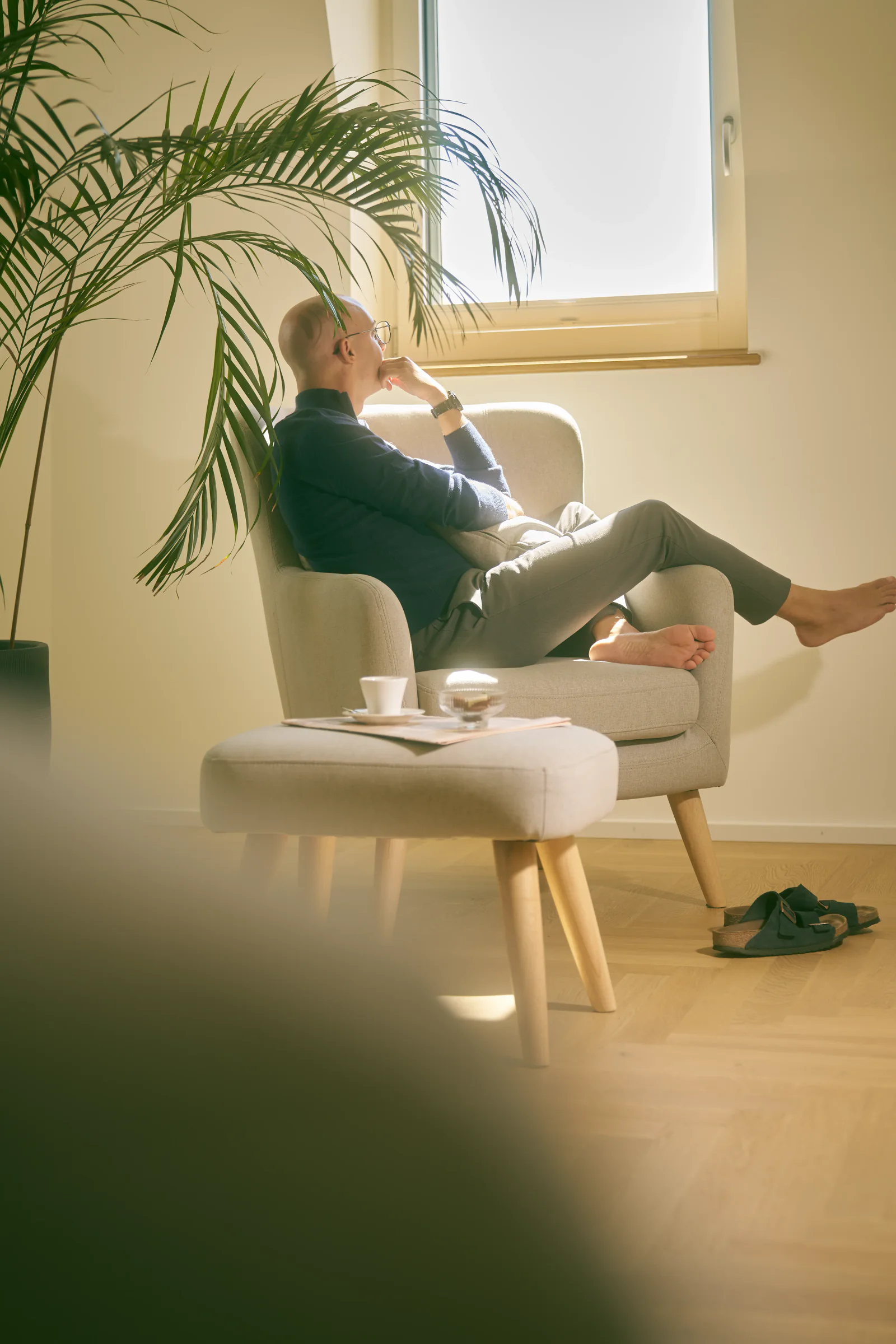 A man sitting in an armchair by a window