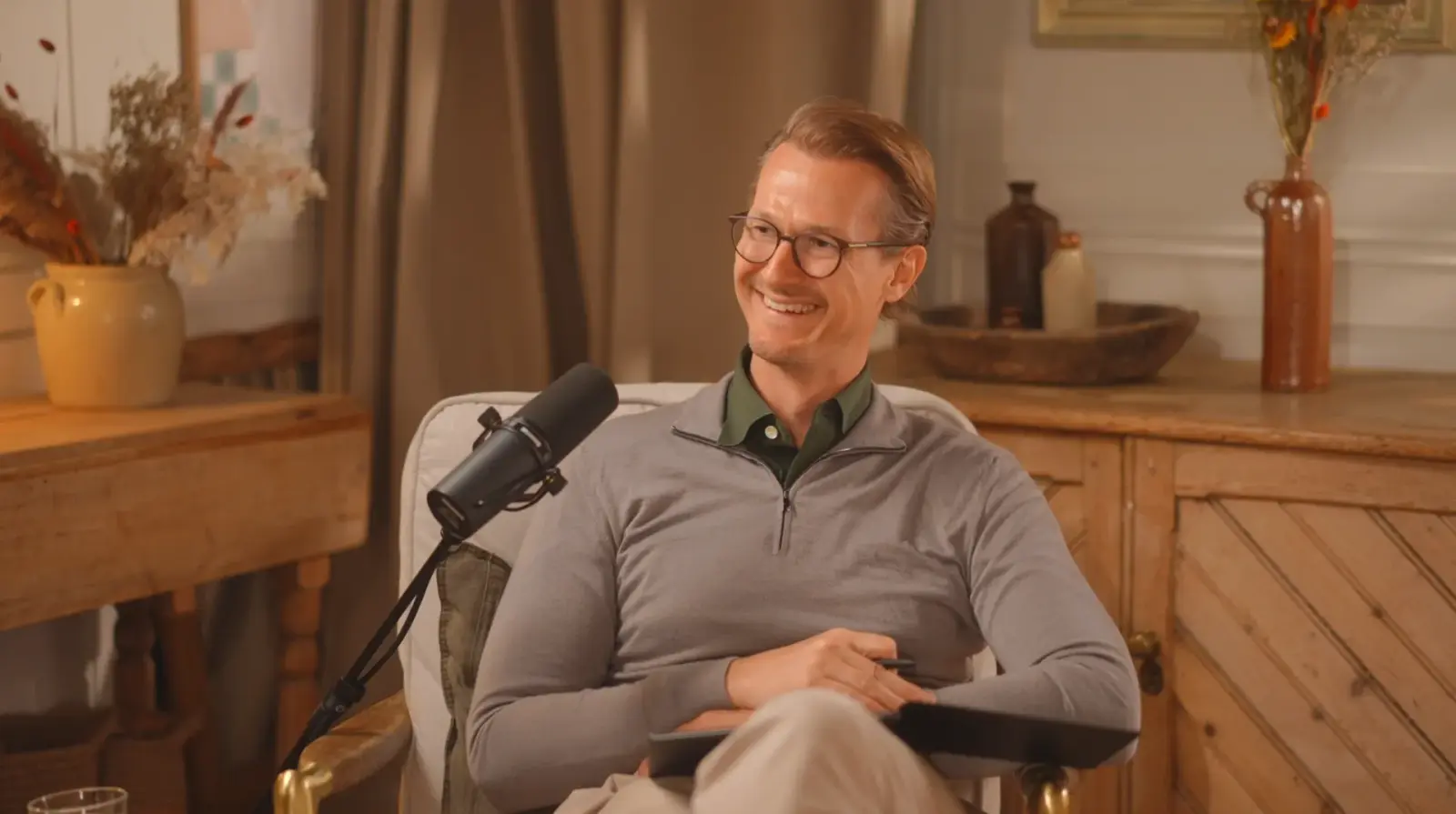 Jan Gerber smiling as he listens to his guest during a podcast recording